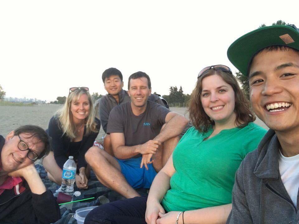 Andrew with a diverse group of friends on a beach